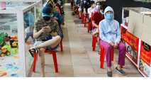 Người dân ngồi chờ đến lượt mua hàng.