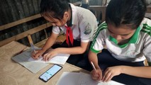 Hai học sinh ở Cần Thơ phải học online chung bằng 1 chiếc điện thoại. Ảnh: Đức Duy