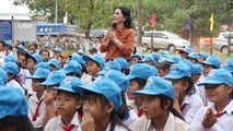 Bà Kim Oanh (người đứng) trong chuyến thăm, hỗ trợ bếp ăn trưa và tặng quà cho học sinh một trường học.