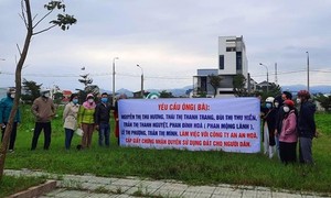 Nhiều người dân cầm băng rôn đến dự án xây nhà ở Khu dân cư thị trấn Núi Thành đò sỏ đỏ.