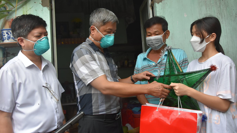 Thứ trưởng Y tế Nguyễn Trường Sơn (thứ 2 từ trái qua) thăm và tặng quà một em nhỏ có người thân mất do COVID-19 tại TP HCM, ngày 20/9/2021.