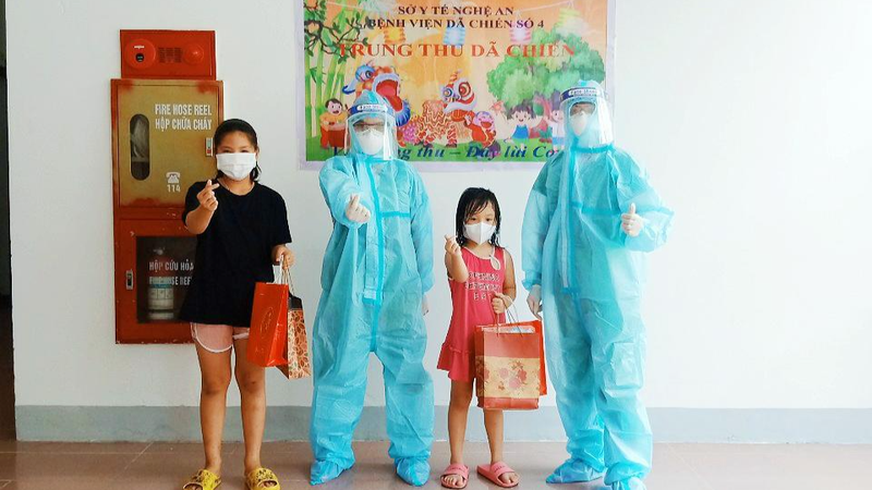 Các y, bác sĩ trao quà cho bệnh nhân “nhí” đang điều trị tại Bệnh viện Dã chiến số 4 Nghệ An.