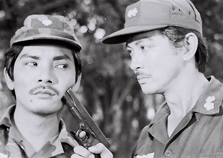 Thương Tín (trái) bên Chánh Tín trong một cảnh quay của Ván bài lật ngửa. Ảnh: Hãng phim Giải Phóng./