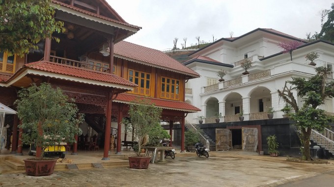 Căn nhà sàn được làm bằng gỗ quý được đặt song song với căn biệt thự khủng.