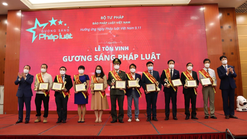 Thứ trưởng Nguyễn Thanh Tịnh (ngoài cùng bìa phải) và Tổng Biên tập Đào Văn Hội (ngoài cùng bìa trái) trao Giấy chứng nhận của Chương trình cho các Gương sáng Pháp luật 2021.