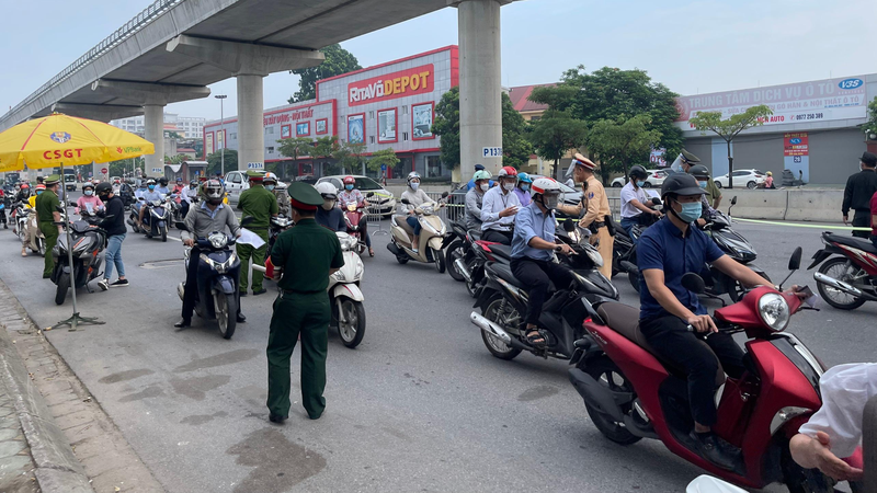 Lực lượng chức năng kiểm tra giấy đi đường của người dân. Ảnh: Mỵ Châu