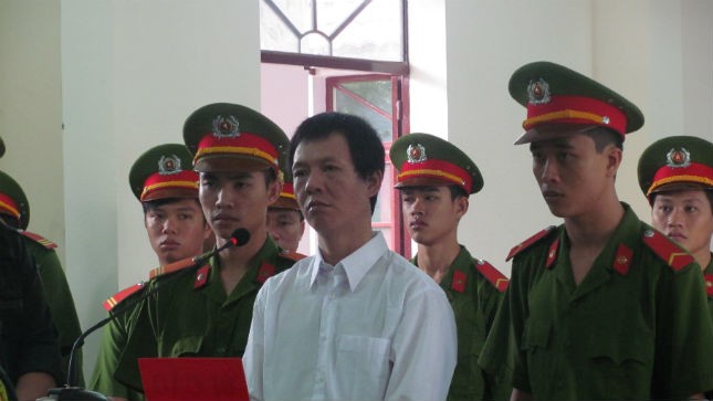 Tử tù Hùng bị áp giải về trại tay vẫn ôm khư khư quyển sách luật.