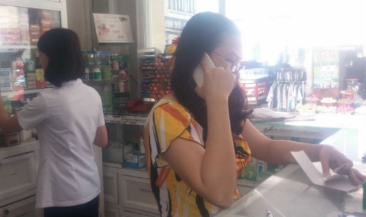 Người người phụ nữ tự xưng là chủ nhà thuốc Thảo Trinh, đang gọi điện thoại lòng vòng cho ai đó và từ chối cung cấp thông tin cho phóng viên. Ảnh: Kim Oanh