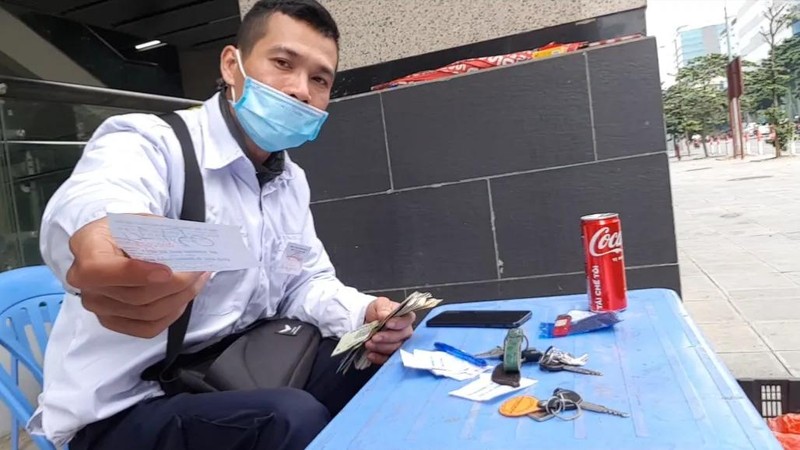 Bảo vệ bãi xe cùng cuống vé đã được chuẩn bị sẵn để ghi vé cho khách.