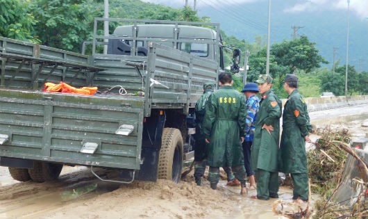 Lực lượng quân đội đang cố khắc phục thông tuyến đường bị đất bùn từ núi đổ xuống.