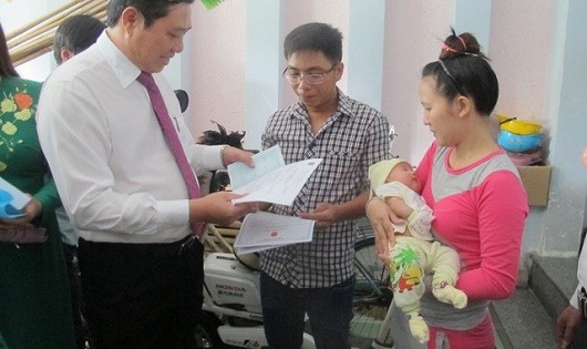 Sẽ sớm thực hiện liên thông thủ tục đăng ký khai sinh và cấp thẻ BHYT cho trẻ em dưới 6 tuổi (trong ảnh: Lãnh đạo TP Đà Nẵng trao giấy khai sinh, thẻ BHYT và sổ hộ khẩu của các em bé tại gia đình).