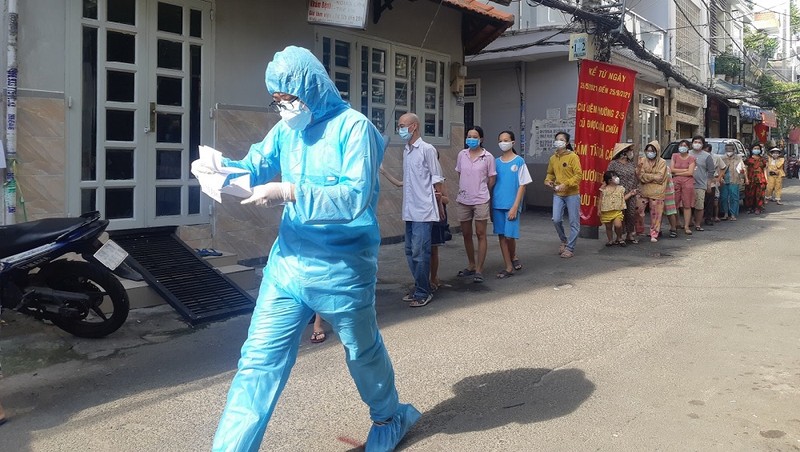 Cán bộ y tế lấy mẫu xét nghiệm COVID-19 cho người dân. Ảnh: HCDC
