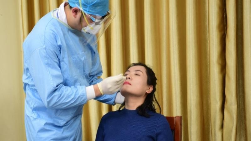 Nhân viên y tế lấy mẫu xét nghiệm SARS-CoV-2 của phóng viên tham dự đưa tin về Đại hội XIII. Ảnh: VOV