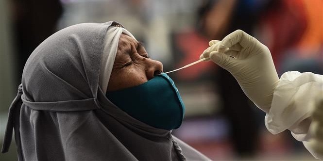 Nhân viên y tế lấy mẫu xét nghiệm Covid-19 cho người dân tại Jakarta, Indonesia ngày 22/12.