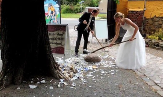 Cặp vợ chồng người Đức cùng nhau quét dọn chén đĩa mà khách mời đập.