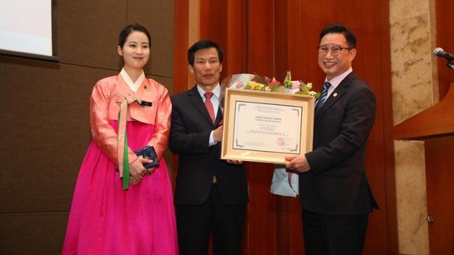Ông Lý Xương Căn (bìa phải) nhận quyết định làm Đại sứ du lịch Việt Nam từ Bộ trưởng Bộ VH,TT&DL Nguyễn NgọcThiện.