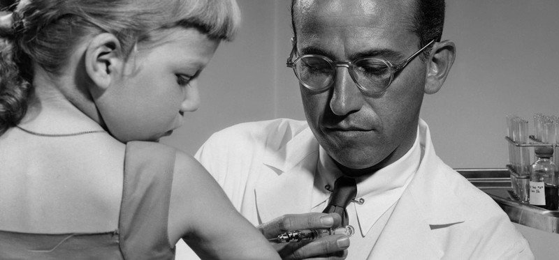Bác sĩ Jonas Salk tiêm vaccine bại liệt thử nghiệm cho một bé gái vào năm 1954. (Ảnh: Getty Images).