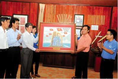 Đại diện Đoàn Thanh niên VNPT trao tặng Bức tranh ghép tem “Đội Hoàng Sa kiêm quản Bắc Hải” cho đại diện Huyện đảo Lý Sơn