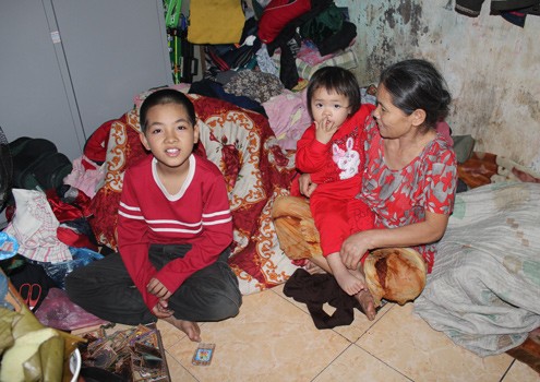Bà Tính cùng hai đứa cháu trong căn nhà chưa có Tết. Ảnh: Bình Minh.
