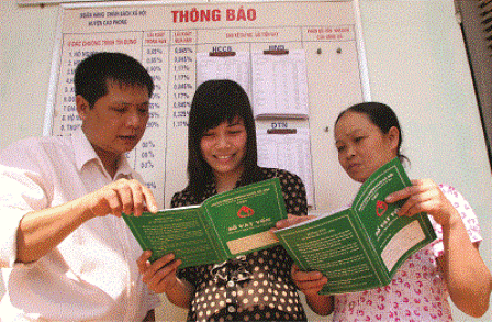 Giám đốc PGD NHCSXH huyện Cao Phong Phí Công Thành đang trao đổi công việc với cán bộ hội đoàn thể cấp xã và Tổ trưởng Tổ TKVV