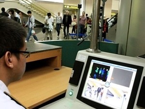 Nhân viên tại Sân bay quốc tế Nội Bài theo dõi thân nhiệt hành khách bằng máy đo tia hồng ngoại.