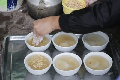 Rắc vừng và dừa lên những bát bánh trôi, bánh chay để tạo hương vị và bánh trở nên đẹp hơn.